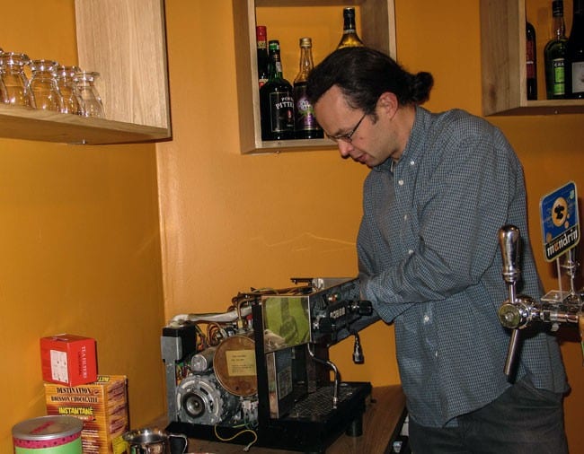 Le gérant du café-vélo de Grenoble derrière son comptoir