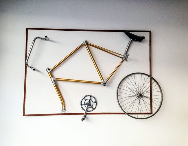 Un vélo sous forme de pièces détachées au mur du café-vélo de Grenoble