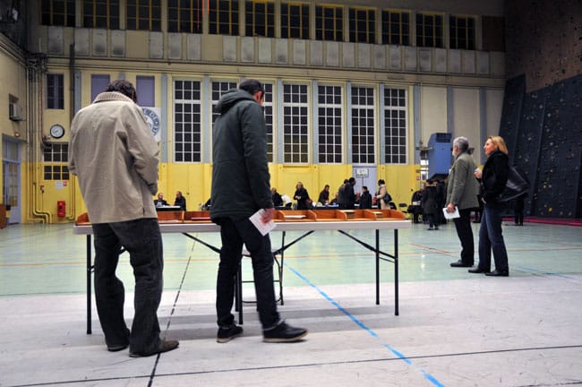 Des électeurs choisissent leur bulletin dans un bureau de vote dans Grenoble à l'occasion des élections départementales 2015 © Muriel Beaudoing - placegrenet.fr