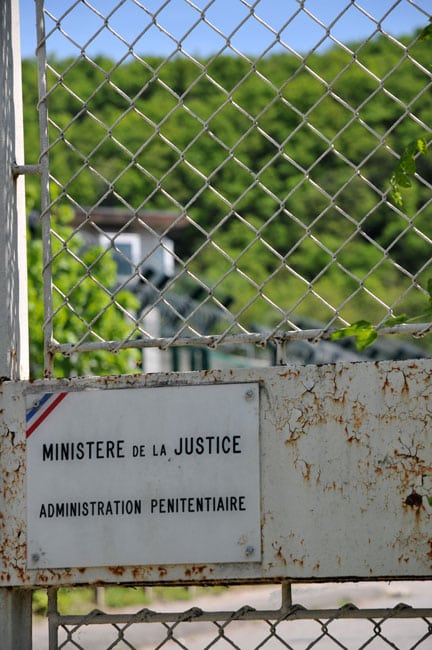 Grille avec un panneau Ministère de la Justice Administration pénitentiaire à l'extérieur de la maison d'arrêt de Varces, près de Grenoble en Isère, prison où André Weill donne des cours de yoga aux détenus. © Paul Turenne - placegrenet.fr