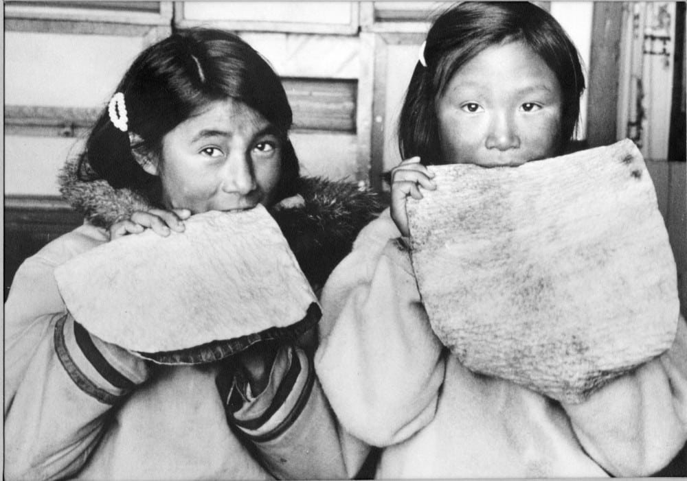 Fillettes mâchant la peau de phoque pour l’assouplir, photographie de R.P. André Chauvel, 1960 Coll. Instut culturel Avataq