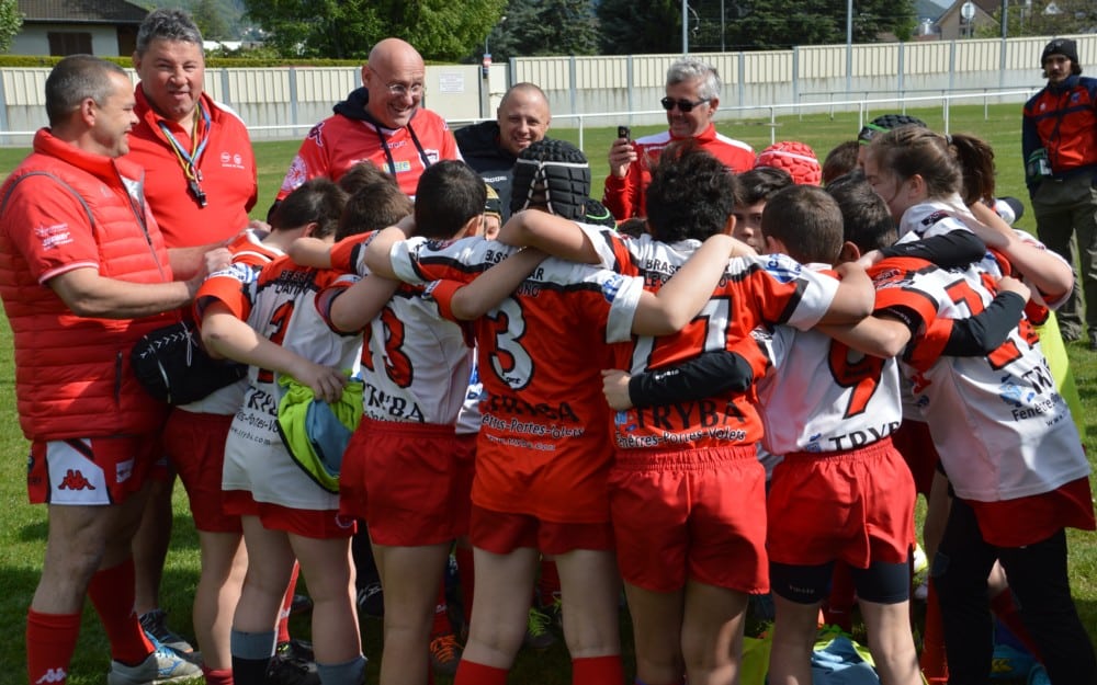 Bernard Laporte, souriant, avec en cercle des jeunes de l'école de rugby de Voiron qui chantent le "Pilou-Pilou", en l'honneur de l'ancien manager de Toulon. © Laurent Genin