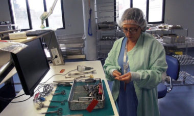 Opératrice de stérilisation vérifiant les instruments d'un panier. © Véronique Magnin - Place Gre'ne