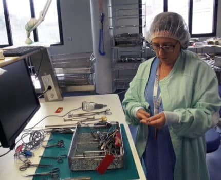 Opératrice de stérilisation vérifiant les instruments d'un panier. © Véronique Magnin - Place Gre'ne