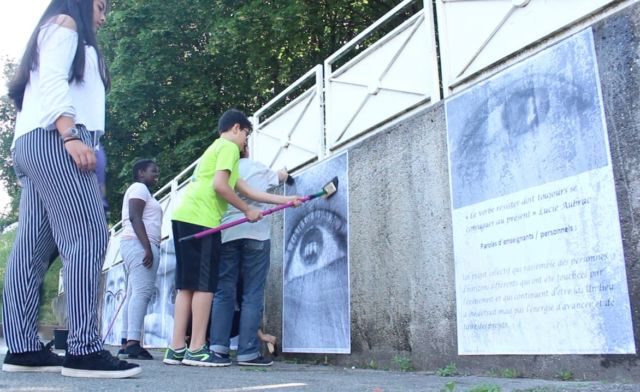 Ce jeudi, les élèves du collège Lucie Aubrac ont procédé à des collages d'affiches sur leur ancien collège, leur nouveau, et le chemin qui relie les deux. Sur les affiches, en plus des photos, on peut voir des phrases concernant le projet artistique, rédigées par les participants.