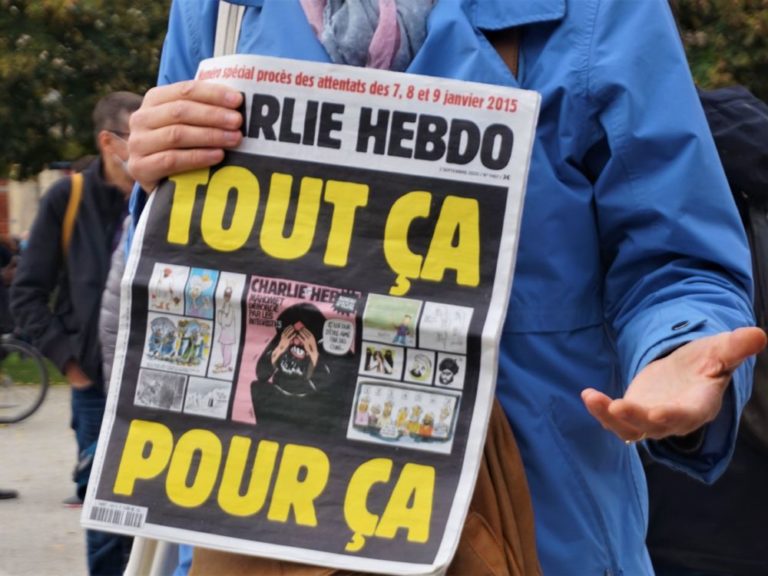 Une manifestante exhibe le numéro de Charlie Hebdo sorti début septembre © Simon Marseille – Place Gre’net