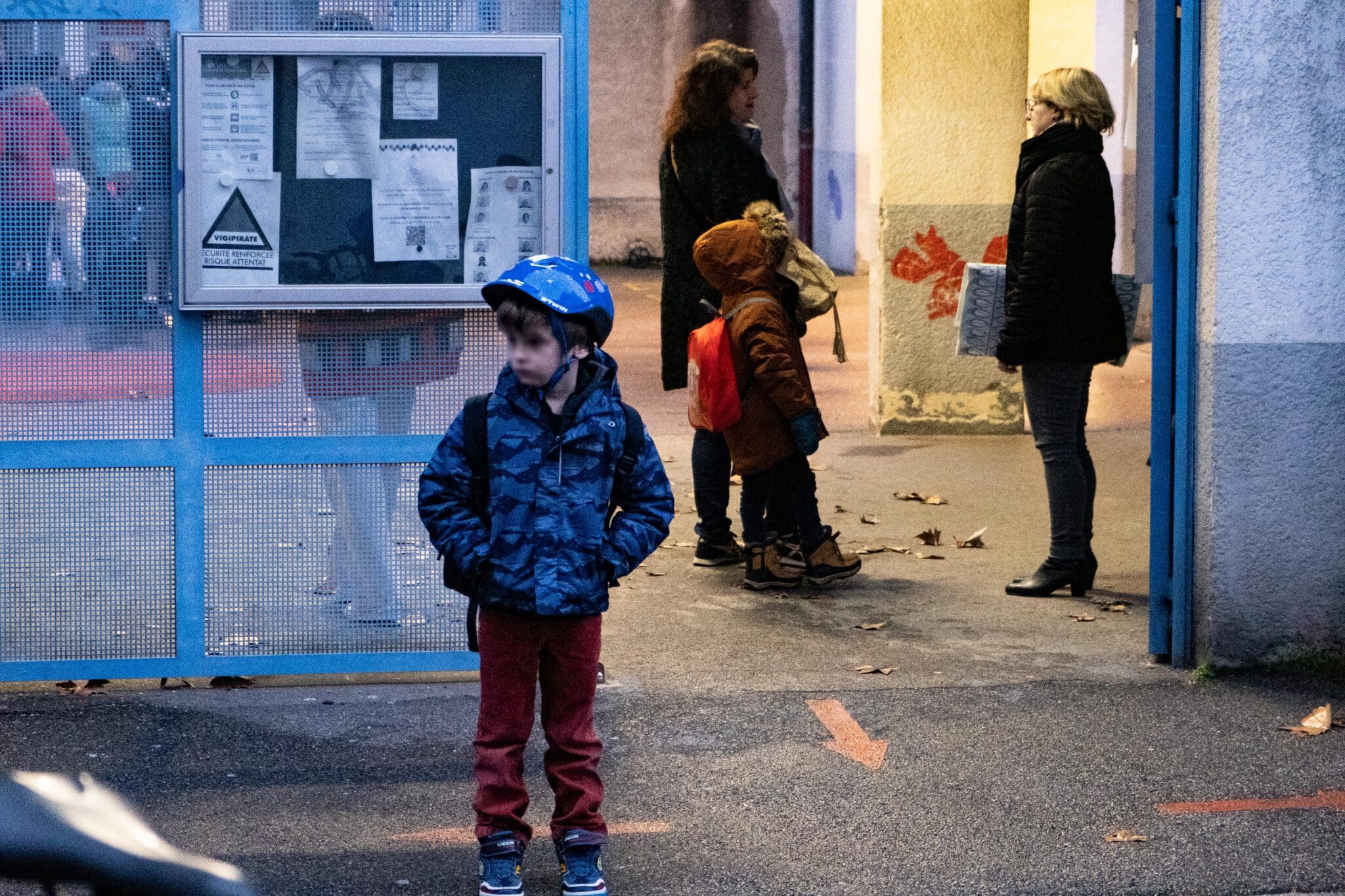 Un enfant attend devant l'école Nicolas Chorier.