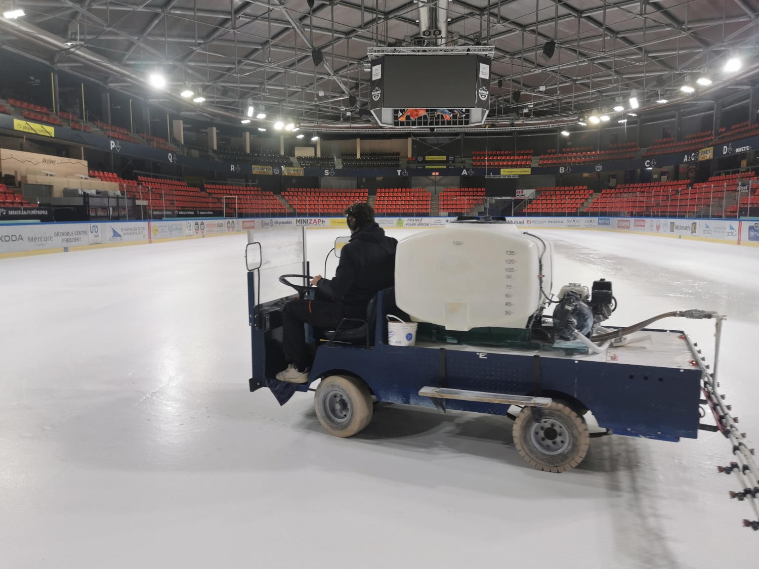 Une machine permet d'appliquer une peinture à l'eau blanche directement sur la glace en formation de la patinoire Polesud. © Joël Kermabon - Place Gre'net