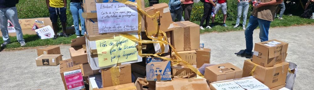 À l'appel de la coordination Bouge ta pref, une pyramide matérialisant symboliquement le nombre de dossiers de titres de séjour en attente a été érigée, mercredi 10 juin 2026 devant la préfecture de l'Isère. © Joël Kermabon - Place Gre'net