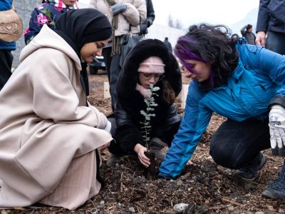 Les adultes aident les jeunes à planter les arbres du futur bosquet boisé du quartier Mistral, lors du COP. Janvier 2023