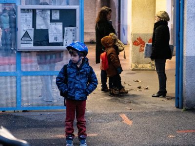 Un enfant attend devant l'école Nicolas Chorier.