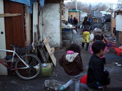 De jeunes enfants s'amusent dans le bidonville avenue Edmond Esmonin à Grenoble avec des cabanes en palettes de bois dans un camp abritant des Roms et des sans abris
