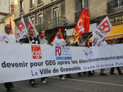 Manifestants salariés de GEG derrière une banderole dans les rues de Grenoble suite à la perte annoncée du marché de l'éclairage public par la Sem Gaz et électricité de Grenoble. © Muriel Beaudoing - placegrenet.fr