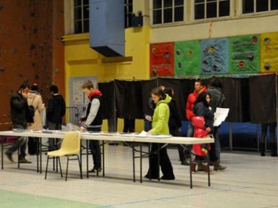 Électeurs devant les isoloirs d'un bureau de vote à Grenoble lors du premier tour des élections municipales 2014